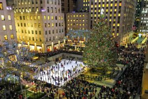A scenic overview of the hustle and bustle of the holidays at night beneath the magnificent tree in Rockefeller Center.